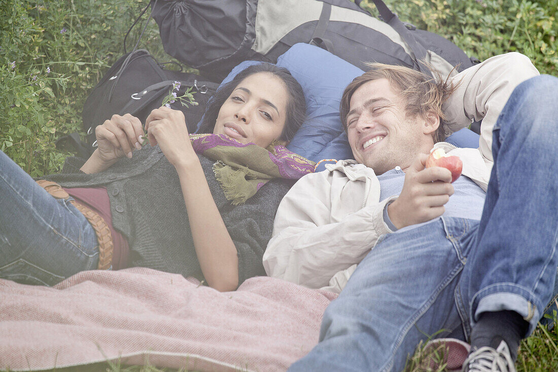 Young couple relaxing in field