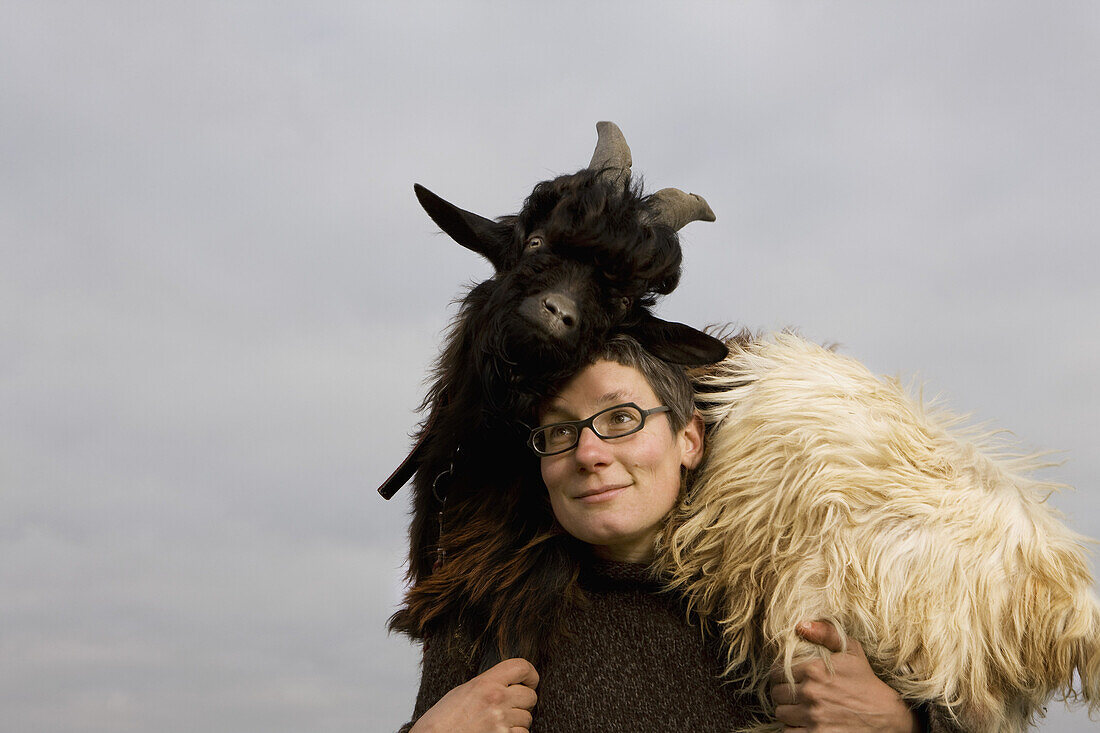 Woman carrying goat on shoulder