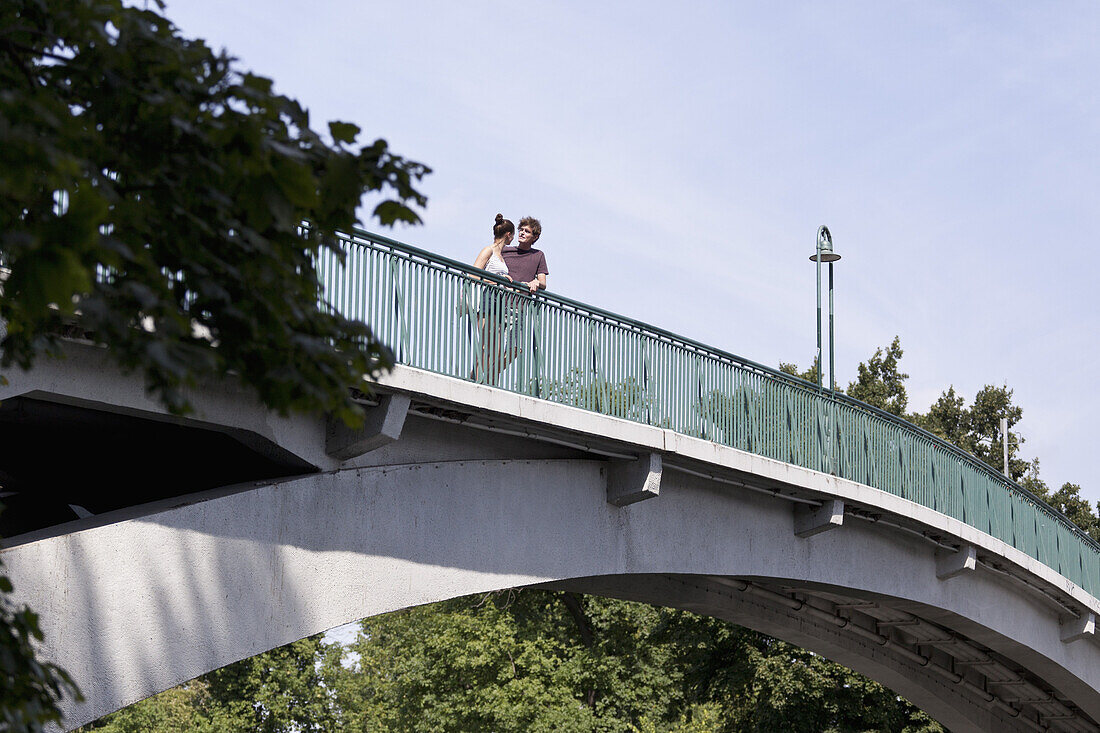 Young couple standing on bridge