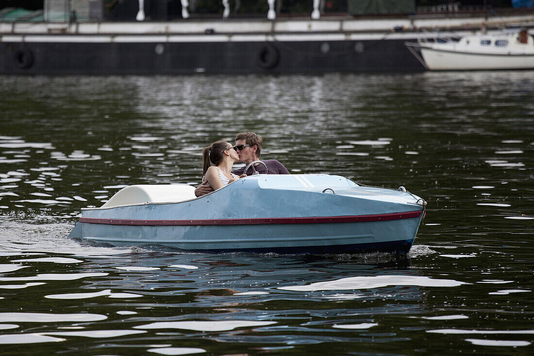 Young couple in paddle boat, kissing