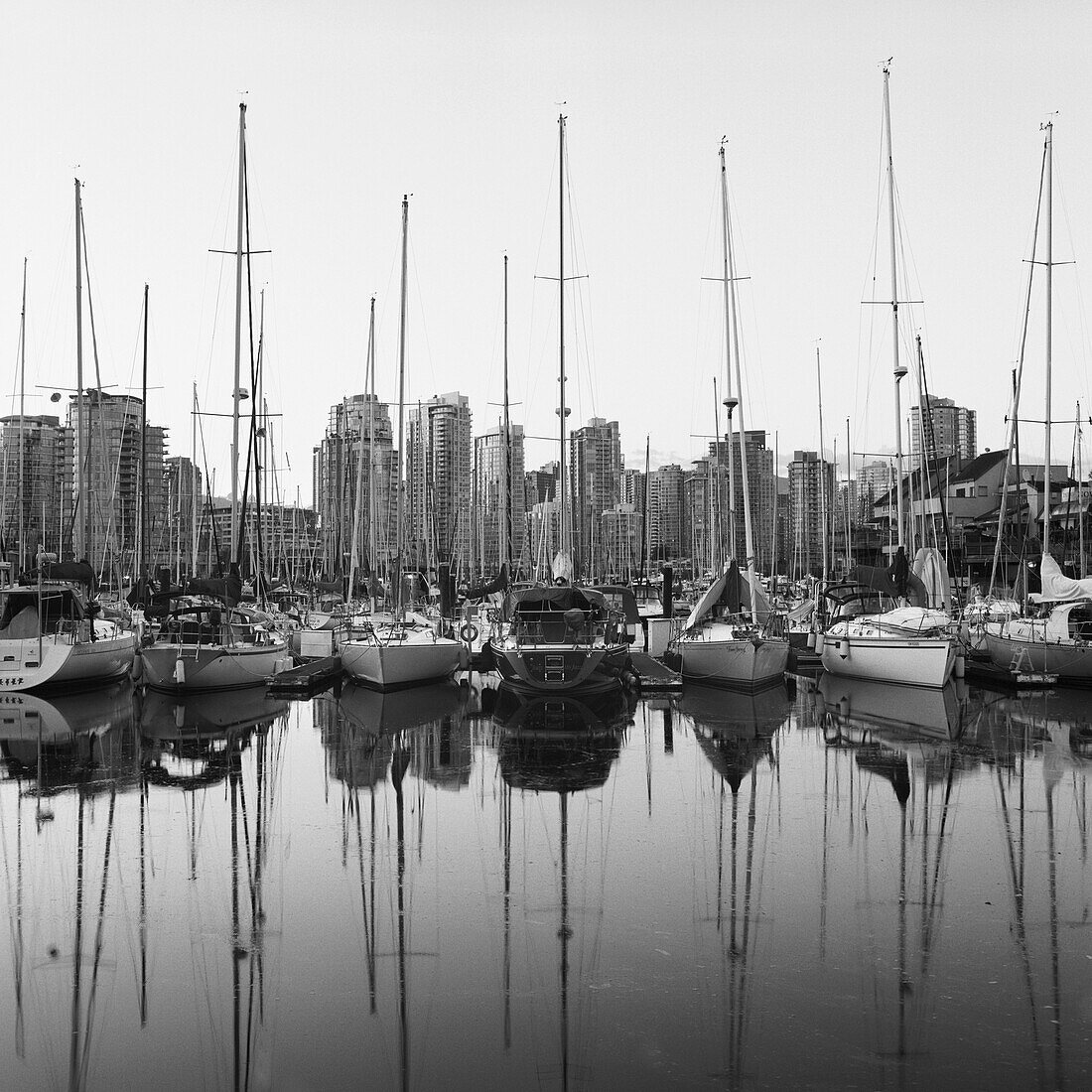 Skyscrapers and boats both reflected in water of marina in Vancouver, British Columbia, Canada