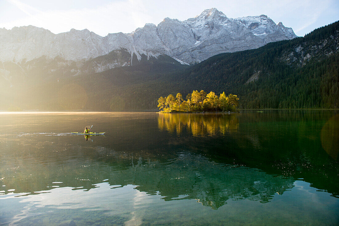 Kayaker paddling on lake Eibsee below Zugspitze, Grainau, Bavaria, Germany