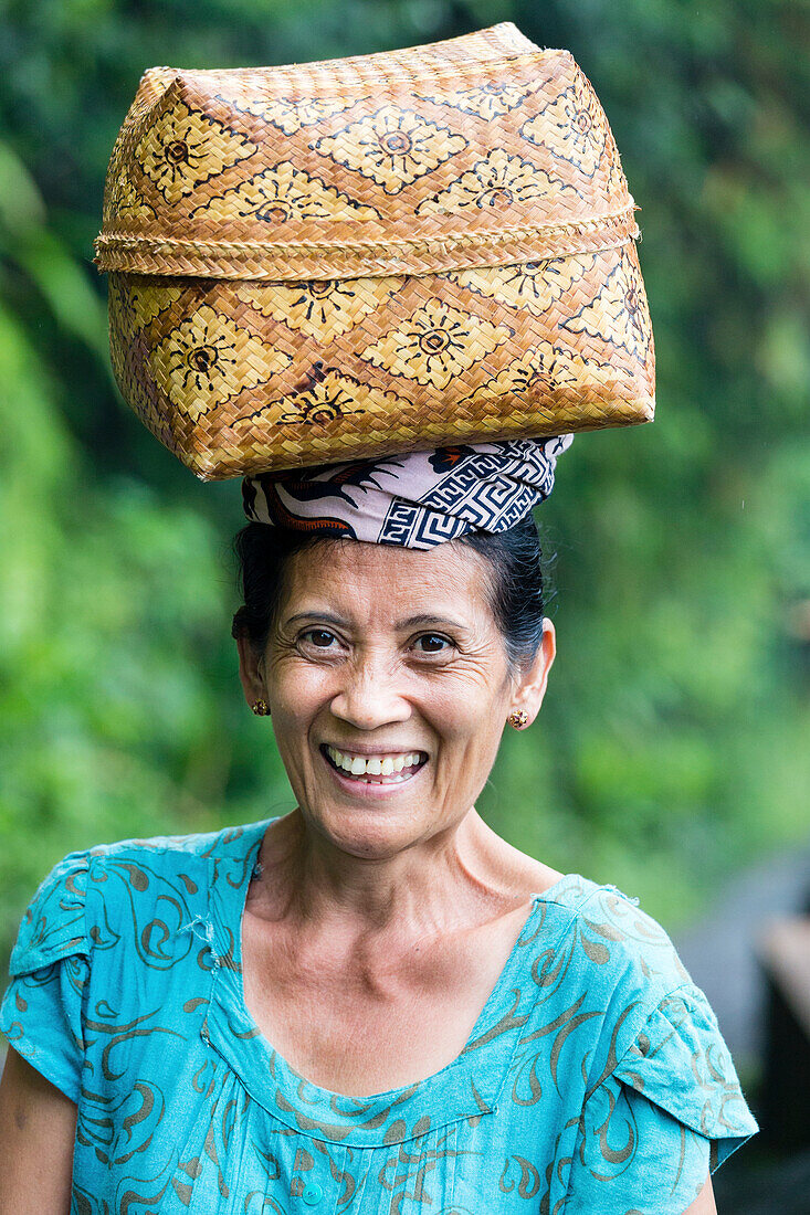 Frau trägt einen Korb auf dem Kopf, Munduk, Bali, Indonesien