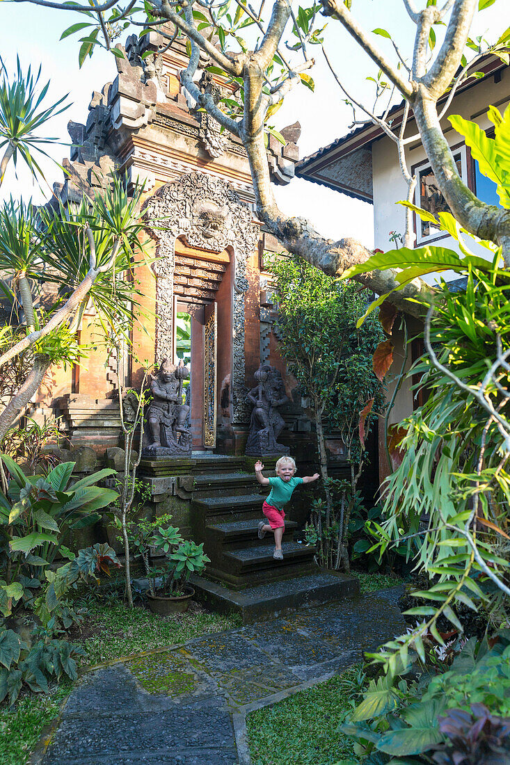 Junge springt von einer Treppe, balinesisches Gartentor, Ubud, Gianyar, Bali, Indonesien