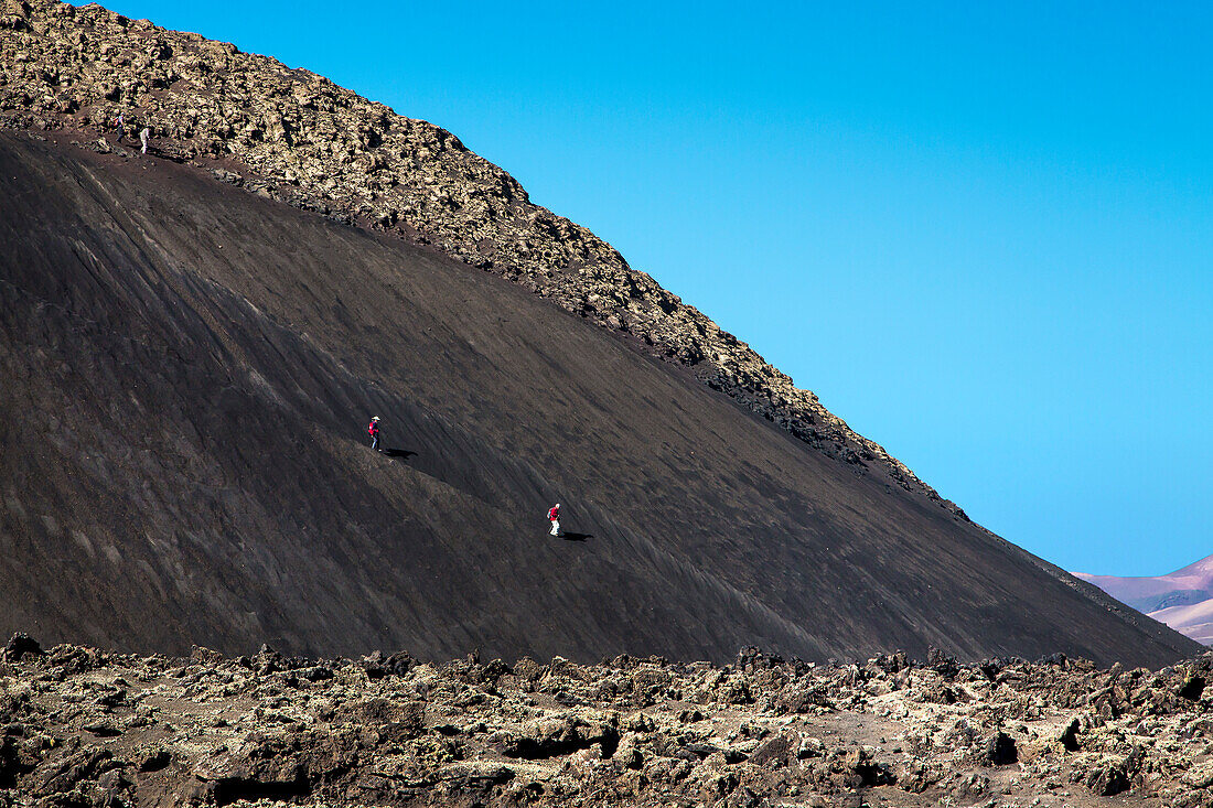 Hiker on the crater montana del Cuervo, Parque de los Volcanes, Lanzarote, Canary Islands, Spain