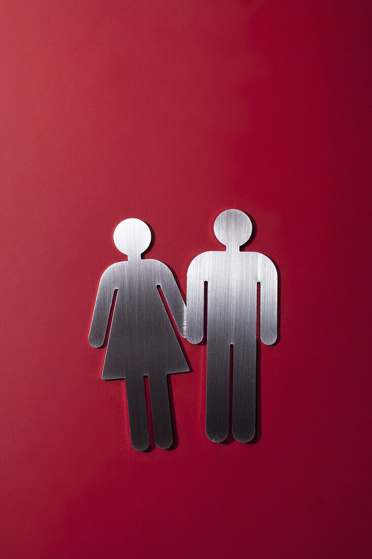 Female and male restroom sign figures holding hands
