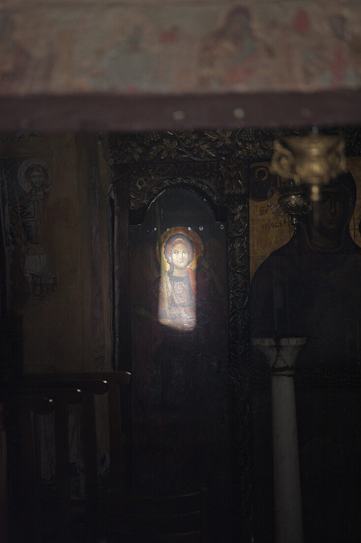 D   Sunbeam through keyhole in church illuminating image of Jesus