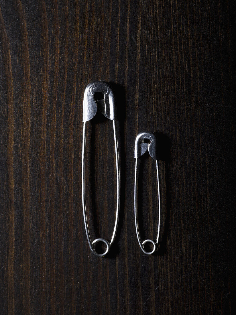 Two different sized safety pins, side by side