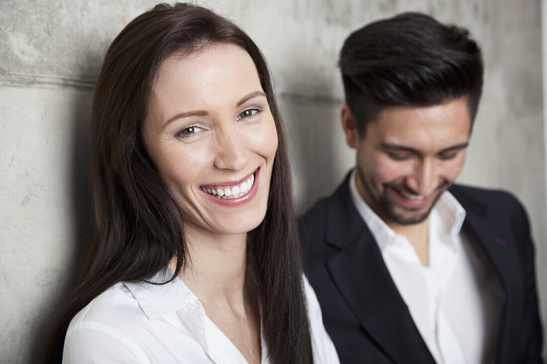 Portrait of a businesswoman and businessman, head and shoulders, focus on woman