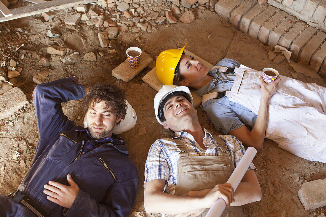 Three construction workers taking a coffee break