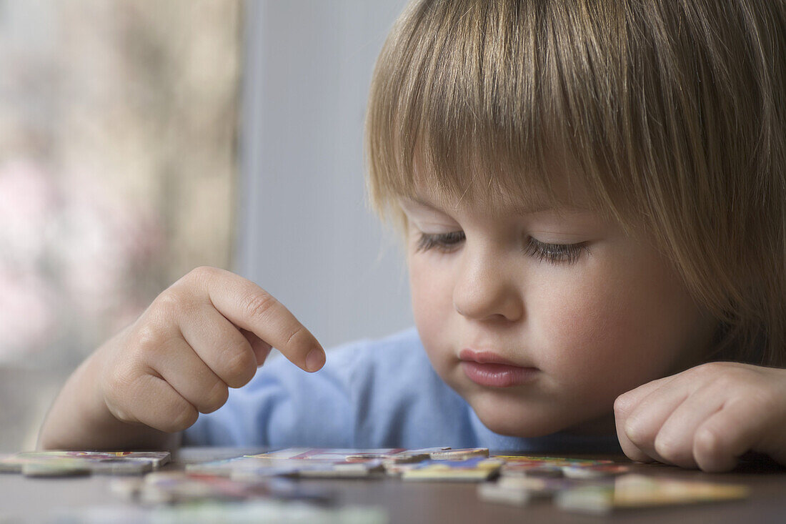 A young boy putting together a puzzle