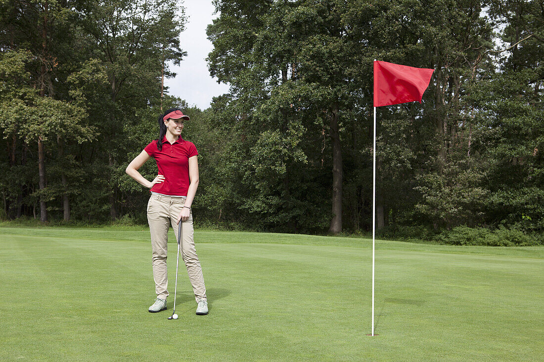 A female golfer standing on a putting green