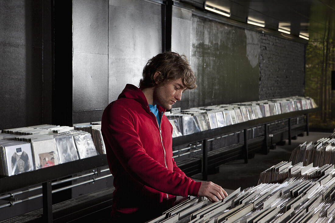 A young man looking through records at a record store