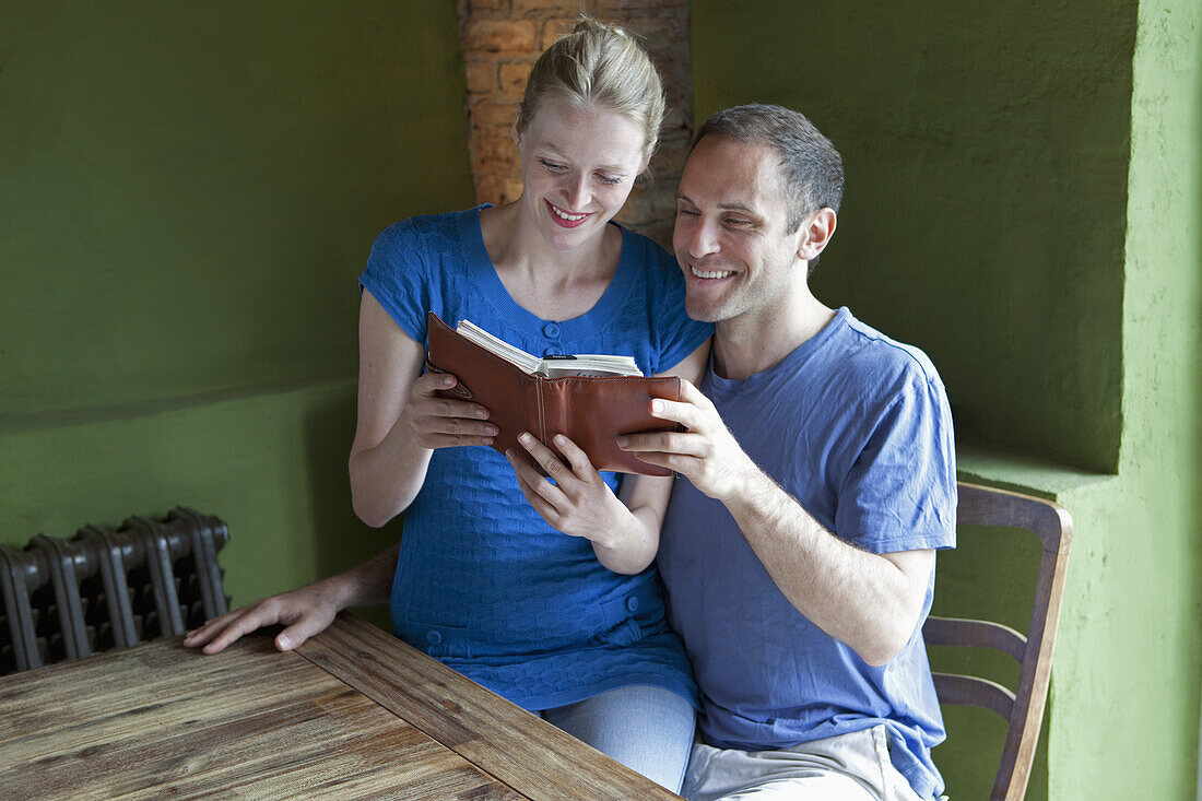 A couple reading a personal organizer together and smiling