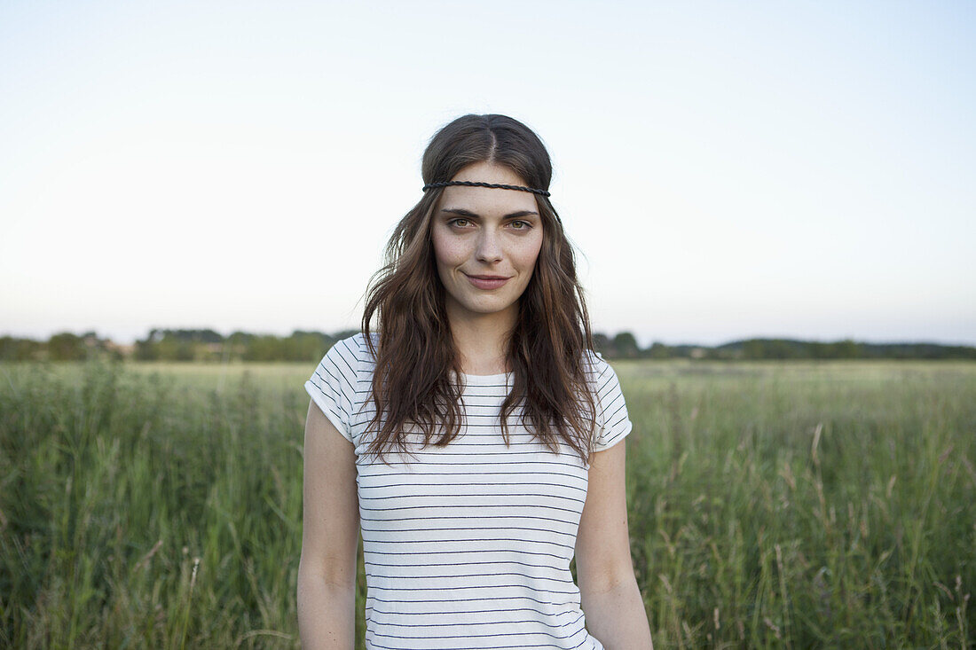 profile of girl with hair band standing in secluded field