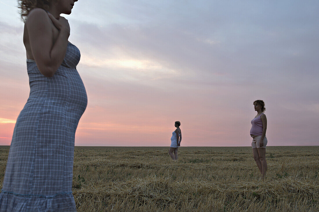 A composite image of three versions of the same pregnant woman in a field