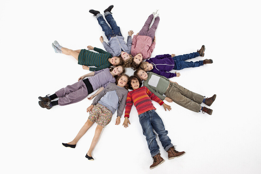 A group of kids lying on their backs in a circle