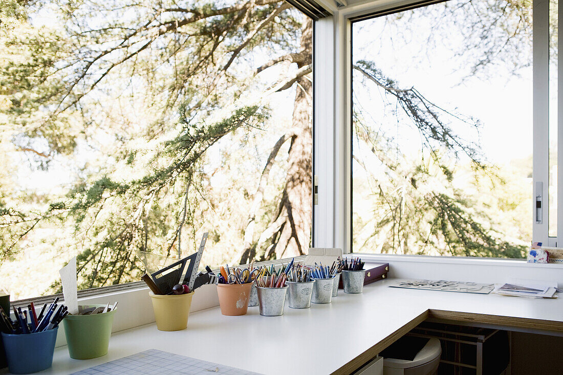 Small office with pots of assorted pens and pencils