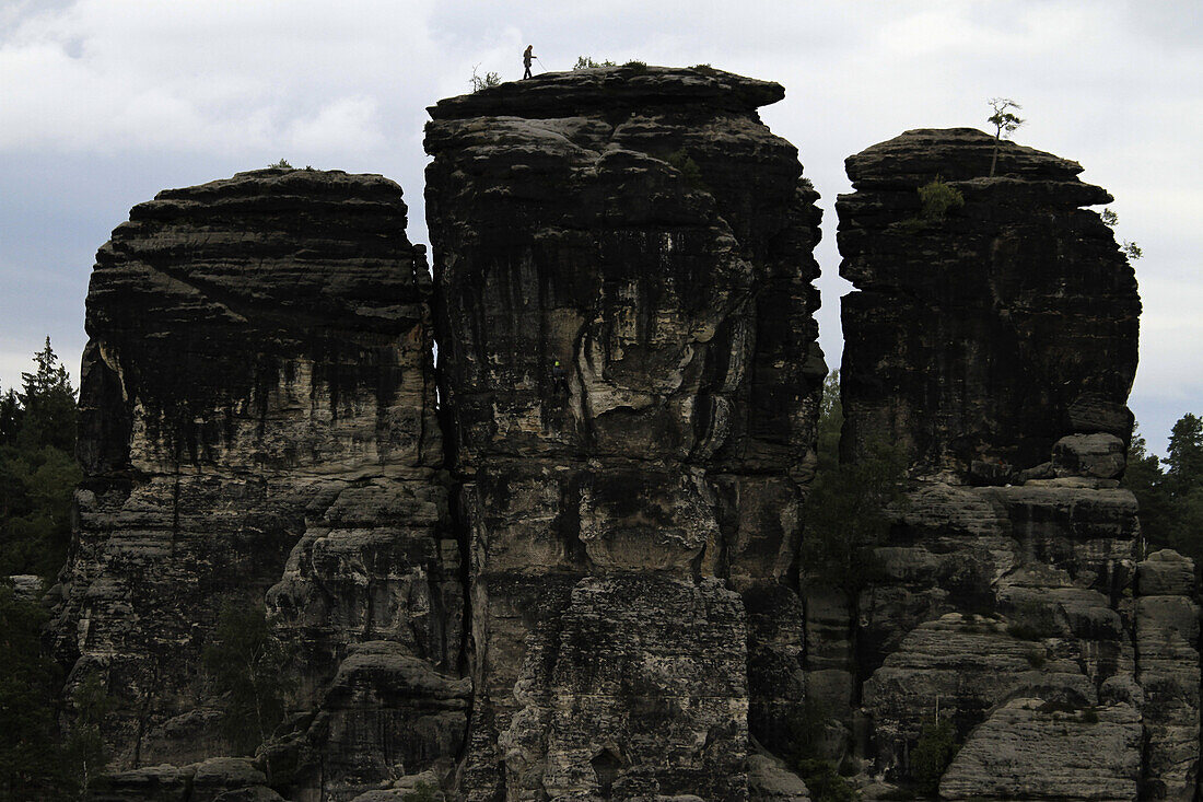 A person climbing a rock formation, Saxon Switzerland, Saxony, Germany
