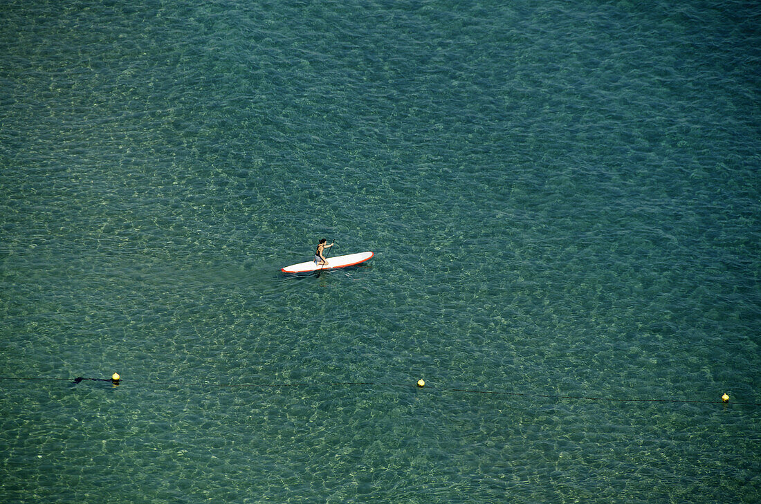 Person rowing on paddleboard on the sea