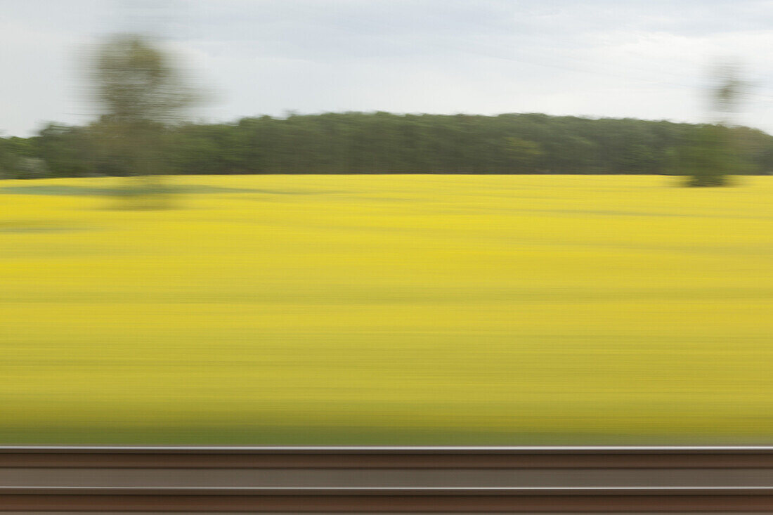 A rural landscape in blurred motion viewed from a moving train