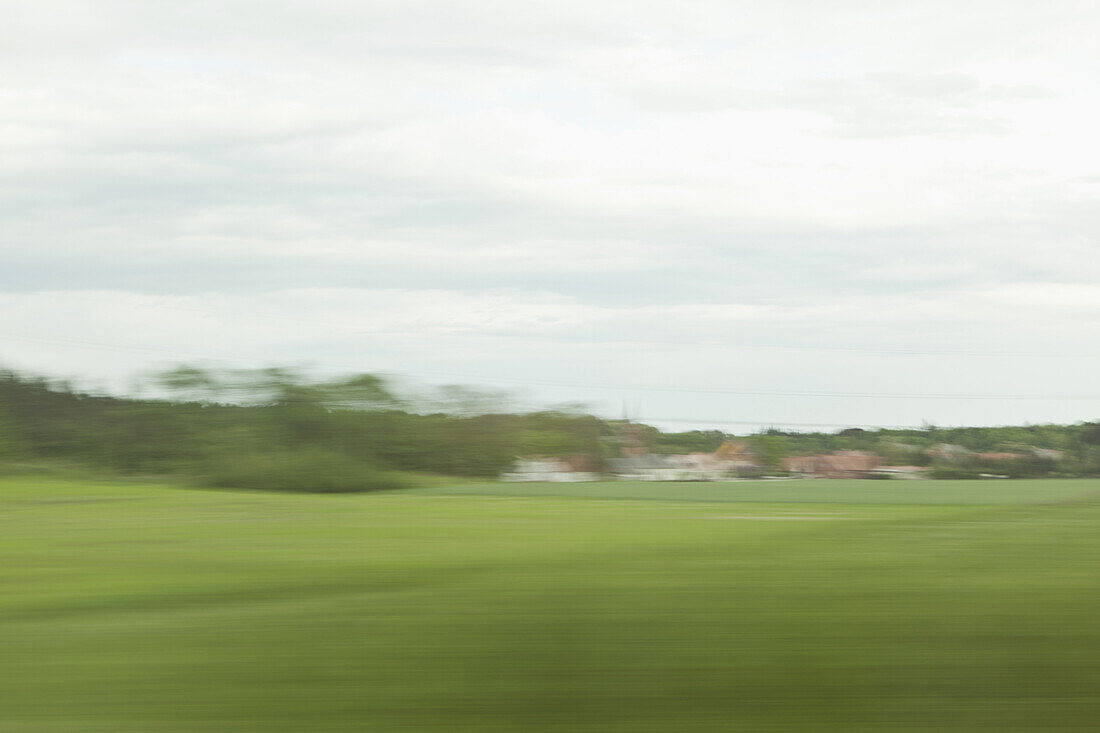 A distant village in blurred motion viewed from moving train