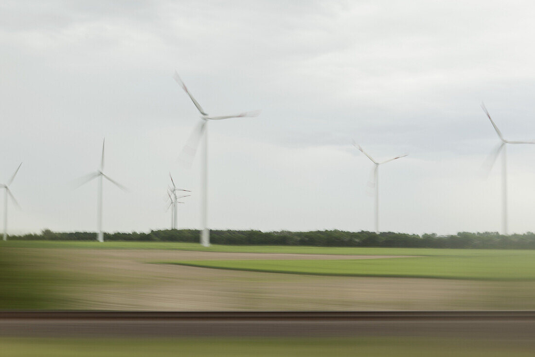 Wind turbines and landscape in blurred motion viewed from moving train