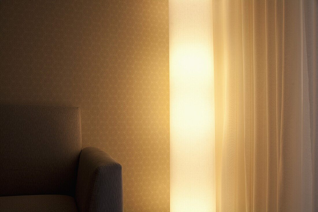 Detail of a light, sofa and curtain in a living room