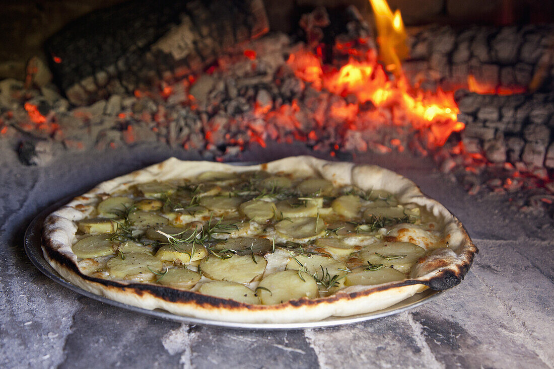 Potato and rosemary pizza baking in oven