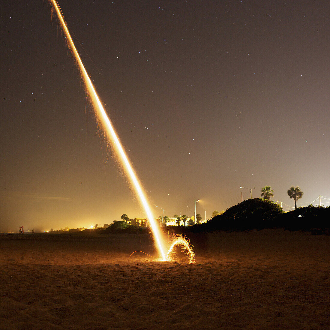A firework exploding on a beach at night