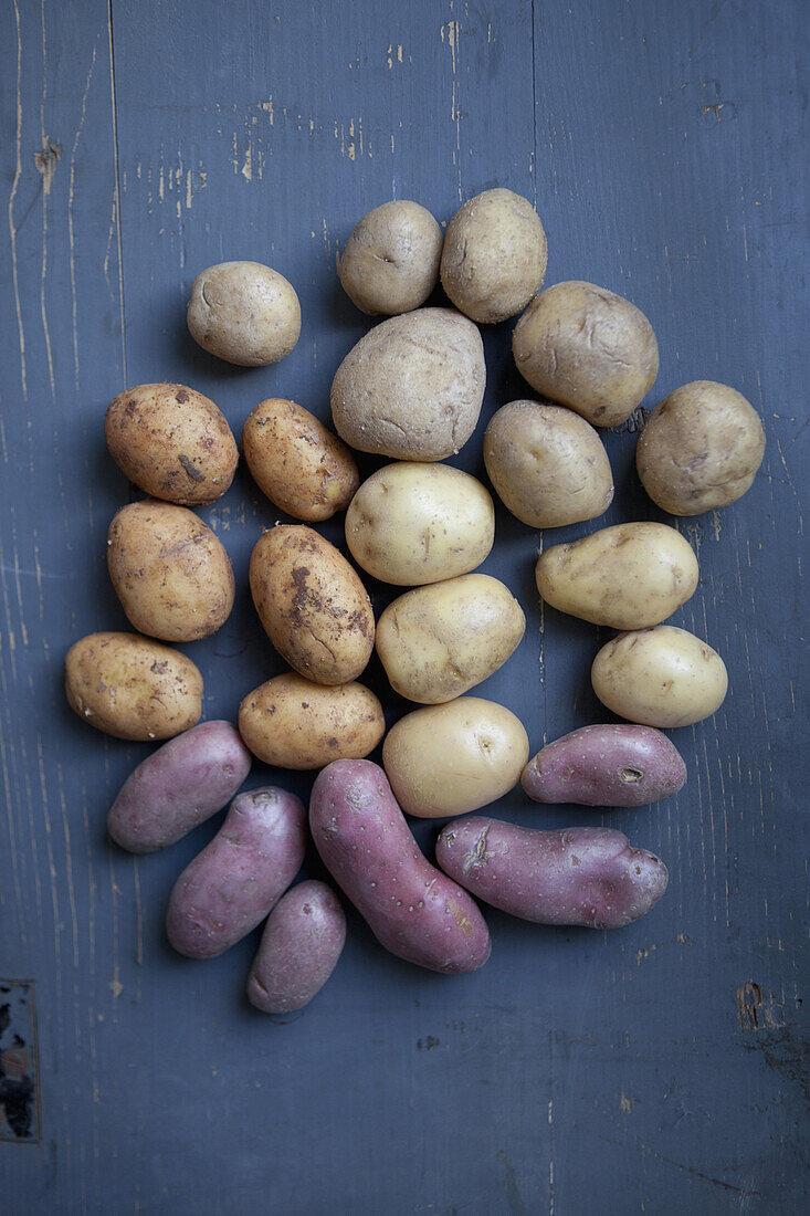 Various potatoes on wooden table