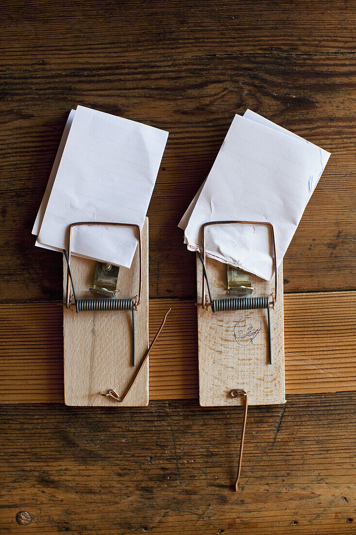 Folded pieces of paper in two mousetraps