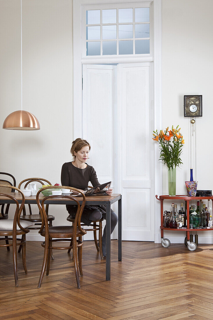 A woman having coffee and reading the newspaper