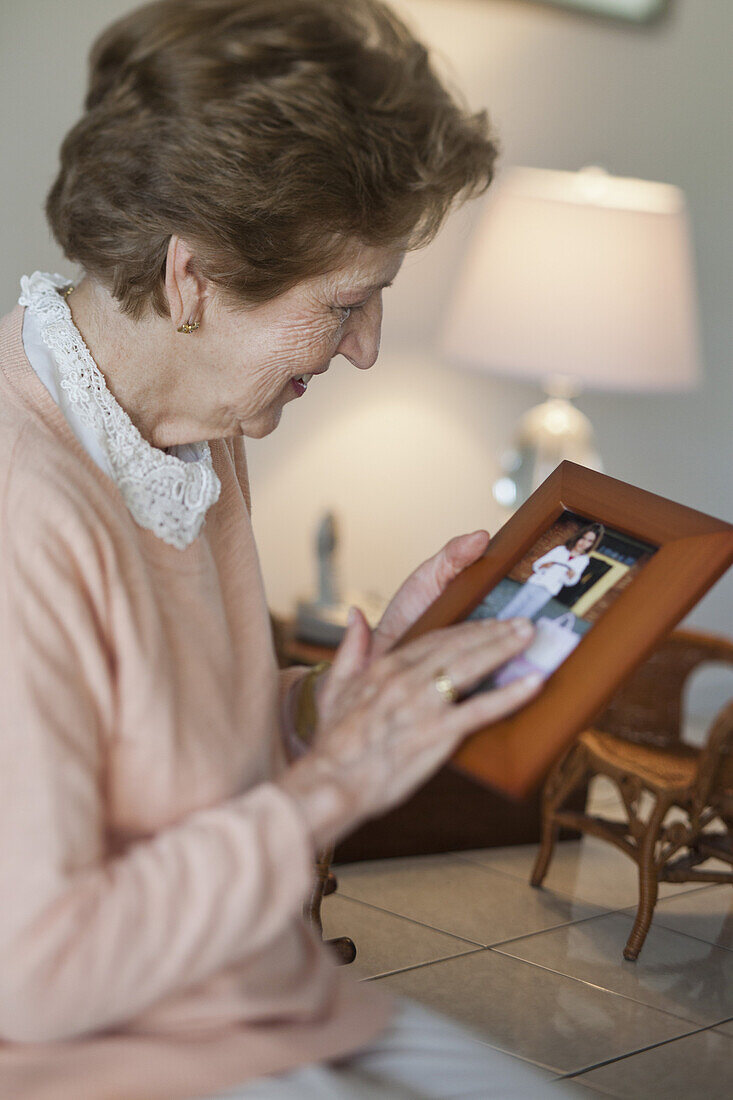Eine ältere Frau hält einen Bilderrahmen