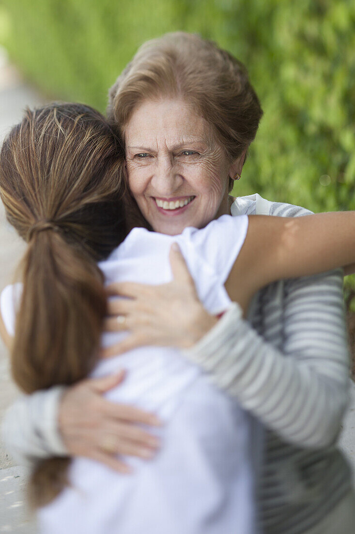 A senior woman hugging a young woman