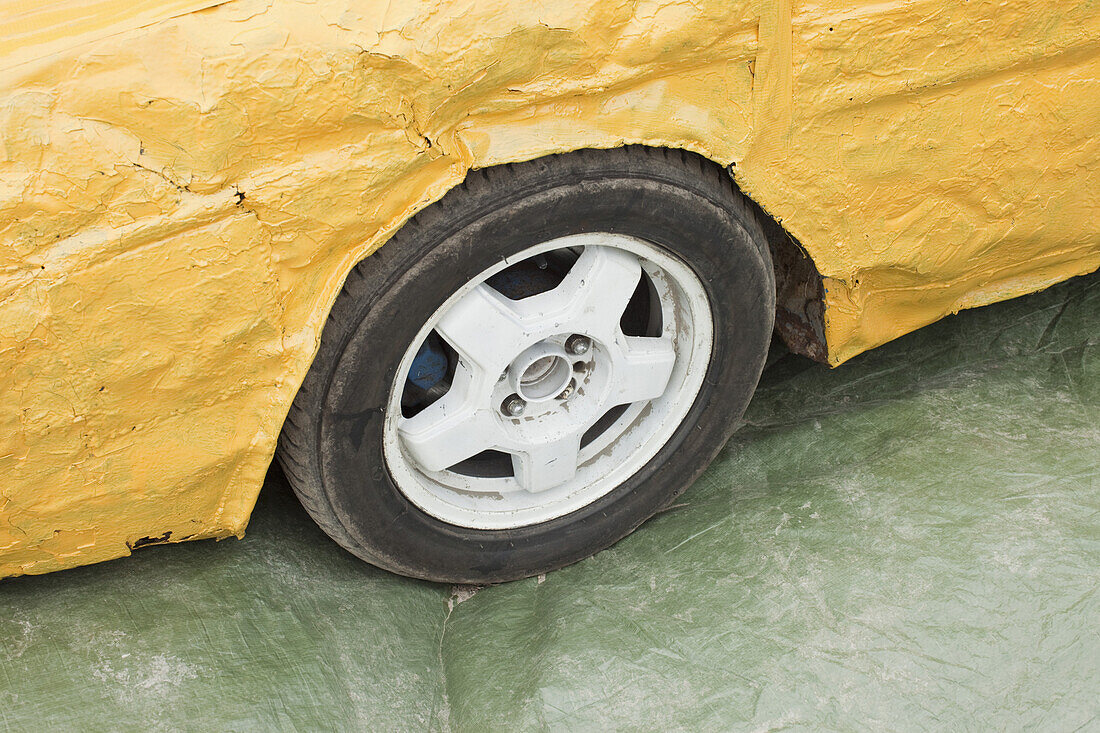 Part of a damaged yellow car