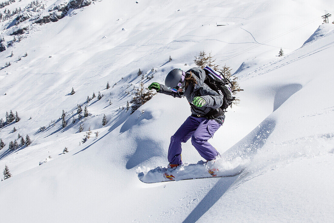 Woman downhill snowboarding, free ride skiing area Haldigrat, Niederrickenbach, Oberdorf, Canton of Nidwalden, Switzerland