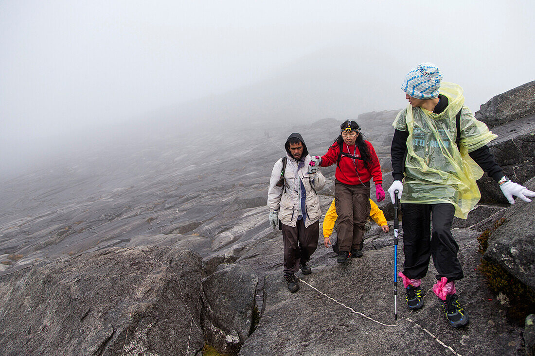 Mountain-Tourists climbing down from the Low's Peak 4091 m, Mount Kinabalu, Borneo, Malaysia.