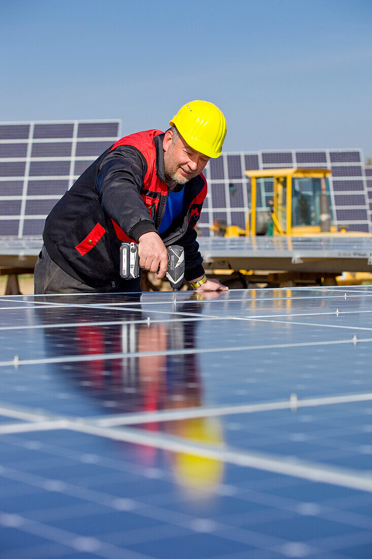 Bauarbeiten auf dem Solarpark am Peterswald, Bauarbeiter mit Helm bei der Arbeit, Neuental, Hessen, Deutschland, Europa