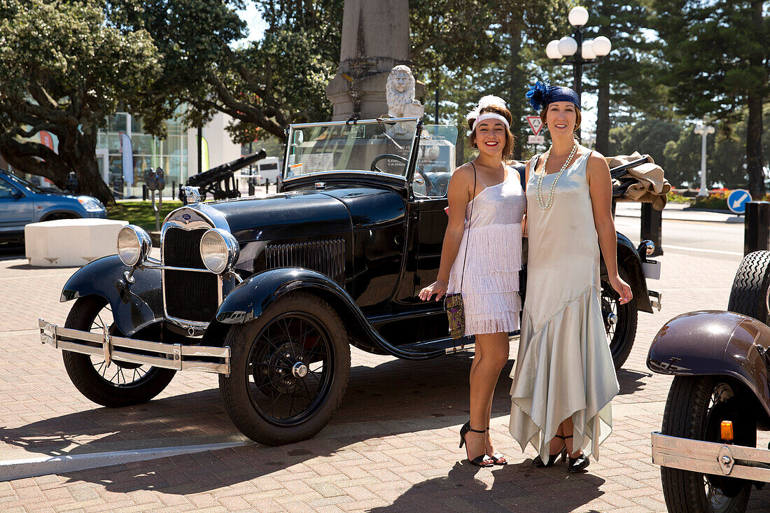 Art deco design: Two women in dresses from the twenties posing in front of a Ford Model A antique car, Napier, Hawke's Bay, North Island, New Zealand
