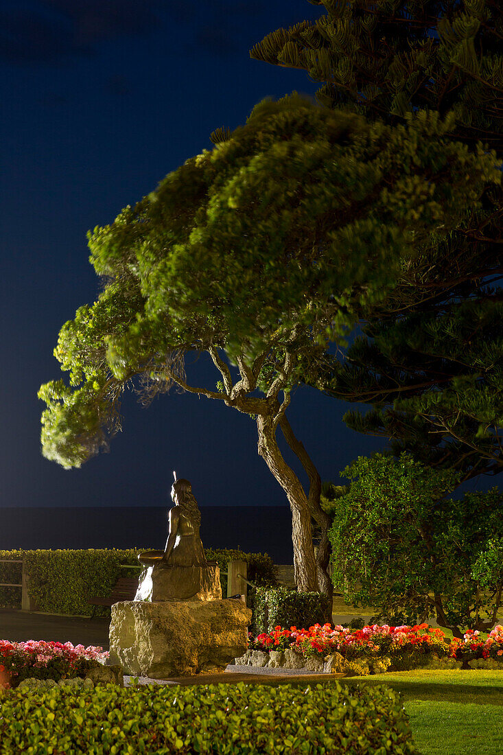 Statue von Pania of the Reef (Meerjungfrau) unter einem Baum am Meer bei Nacht, Napier, Hawke's Bay, Nordinsel, Neuseeland