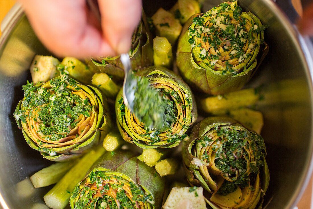 mamma preparing artichokes to cook, traditional, home made, Italy