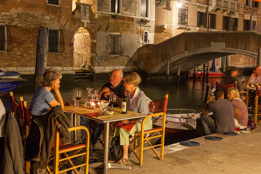 Al Timon Restaurant tables at the canal, Fondamenta Ormesini, summer evening, Cannaregio, Venice, Italy