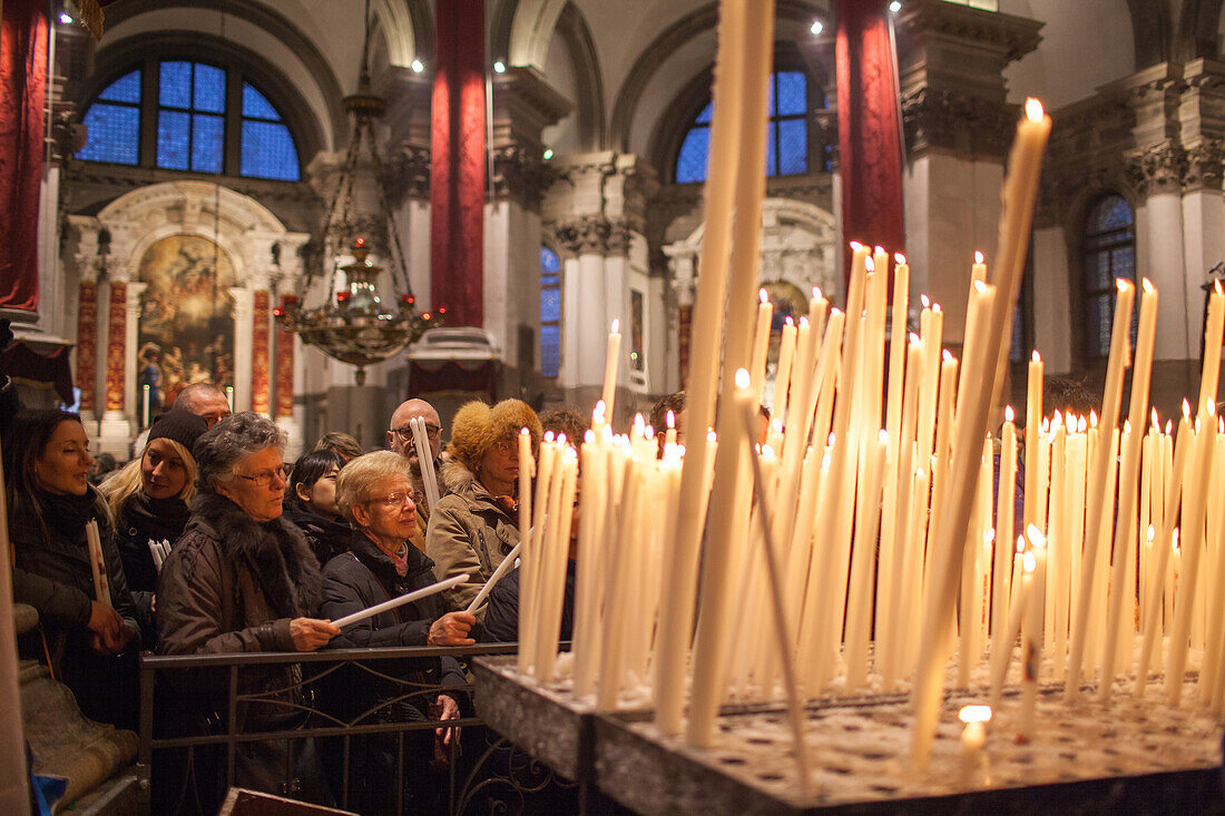 candles being lit in Santa Maria della Salute church, built in gratitude of surviving the plague, an annual memorial festival is held in November, Venice Italy