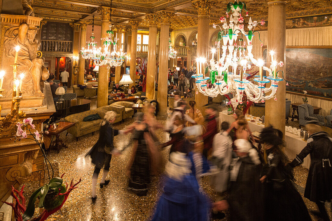 Carneval, dancing guests in costumes, Palazzo Zeno ai Frari, piano nobile, noble floor, private masked ball, carnival, chandelier Murano glass, Hotel Danieli, Venice, Italy