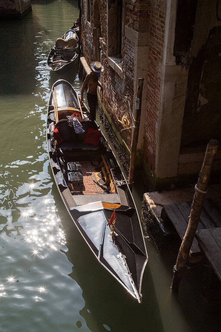 Gondelanleger, Boot, Gondel, Gondeliere in einem engen Kanal in Castello, Lagune von Venedig, Italien