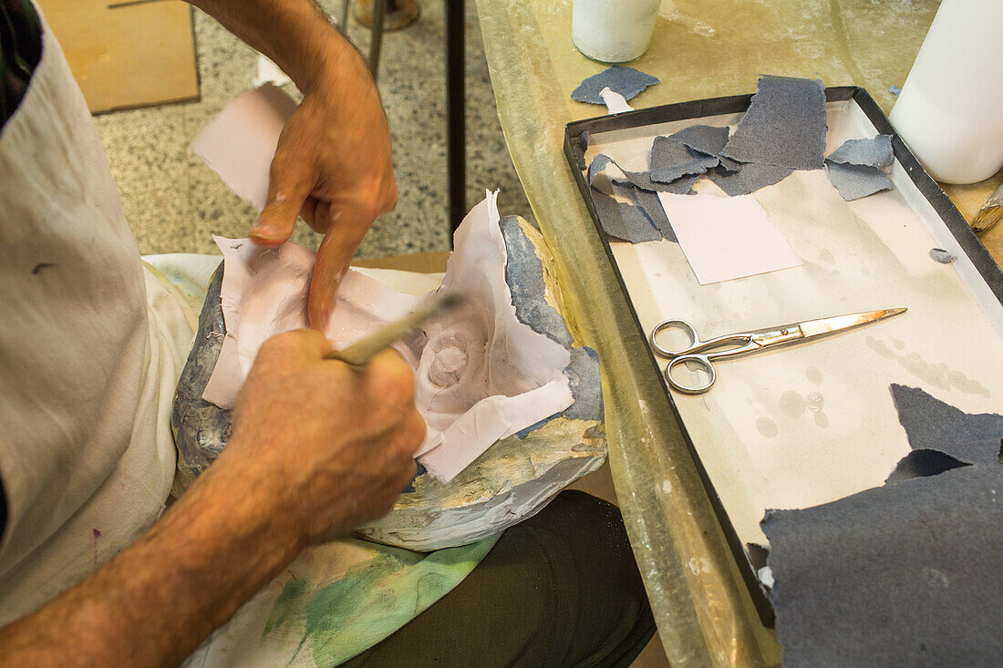 Maskenmacher in seinem Studio, Herstellung von traditionellen Masken mit Leim und Pappmaschee, Venedig, Italien