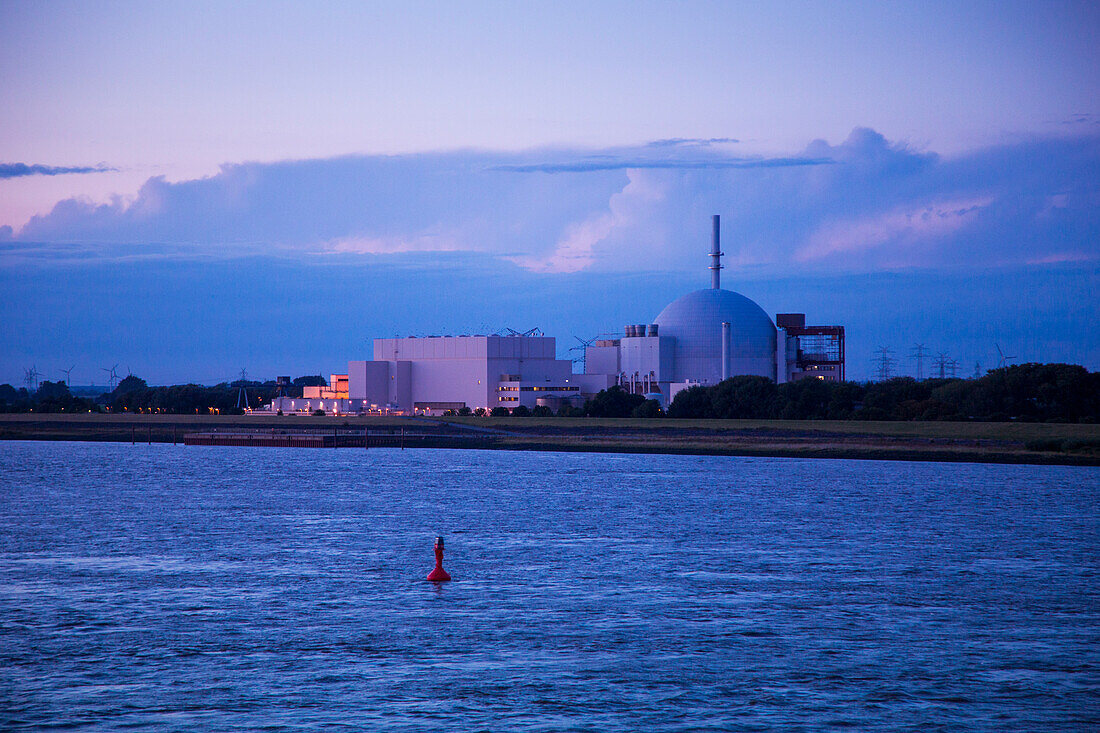 Das abgeschaltete Kernkraftwerk Stade am Ufer von Fluss Elbe in der Abenddämmerung, Stade, Niedersachsen, Deutschland, Europa