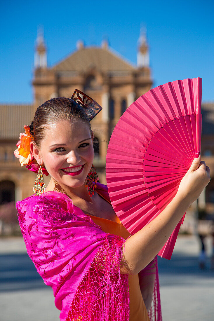 Hübsche junge Tänzerin der Flamenco Fuego Tanzgruppe mit rotem Fächer an der Plaza de Espana, Sevilla, Andalusien, Spanien, Europa