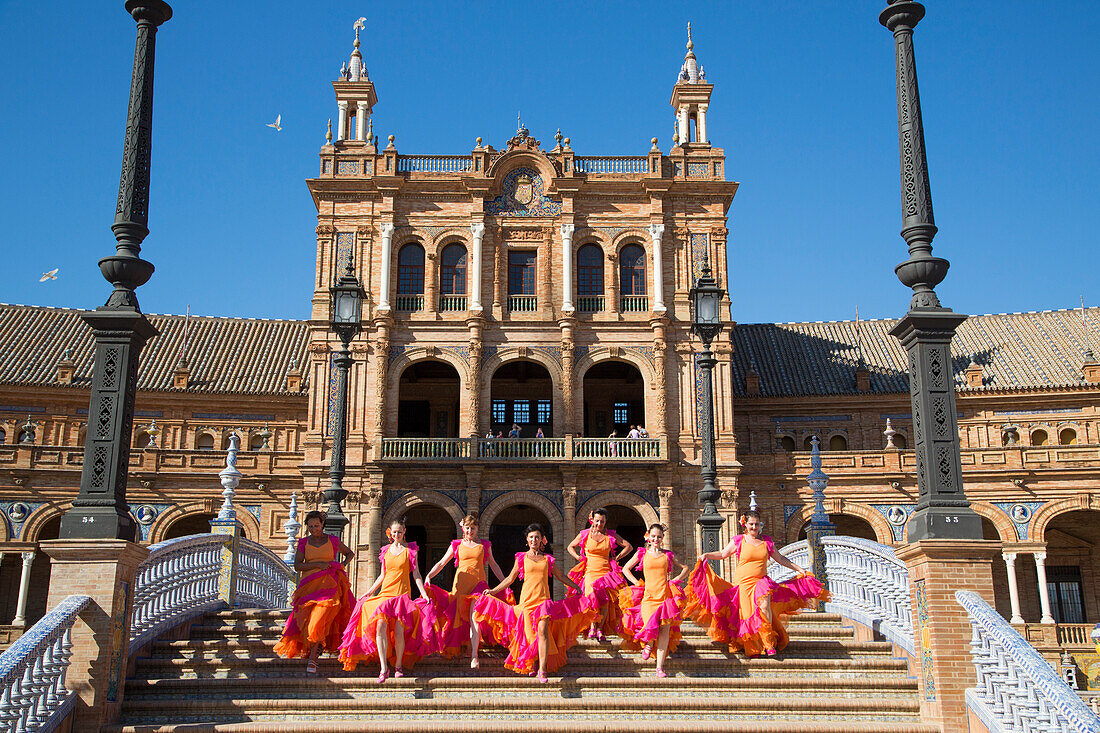 Kostümierte Tänzerinnen der Flamenco Fuego Tanzgruppe rennen eine Treppe an der Plaza de Espana hinab, Sevilla, Andalusien, Spanien, Europa